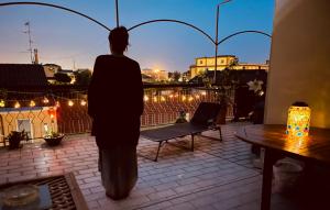 a woman walking on a balcony looking out at the city at B&BMagicHouse in Novara