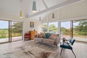 a living room with a couch and some windows at Private Beach with Incredible Views on Lt Island in Wellfleet