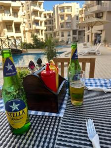 a table with two bottles and a glass of beer at Luxury Aqua Tropical Resort Next To Al Gouna 4 0 1 in Hurghada