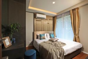 a bedroom with a large bed with a window at 3bdr SeaView Apartment in Surin Beach by Capital Pro in Phuket Town