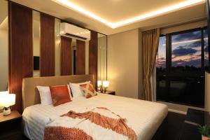 a bedroom with a bed and a large window at 3bdr SeaView Apartment in Surin Beach by Capital Pro in Phuket Town