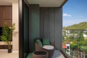 a room with a balcony with a chair and a window at 3bdr SeaView Apartment in Surin Beach by Capital Pro in Phuket Town +35 photos