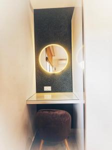 a bathroom with a mirror and a brown stool at Country View Retreat in Żabbar