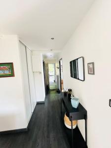 Montcy-Saint-PierreにあるLe Saint Jeanの白い壁と黒いテーブルと鏡のある廊下