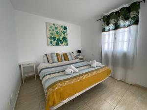a bedroom with a bed with towels on it at Vivilanza Surfhouse in Costa Teguise +14 photos