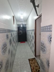 ein Flur mit einer schwarzen Tür und einem Fliesenboden in der Unterkunft Marrakech in Marrakesch + 19 Fotos
