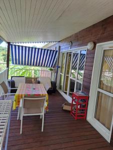 a porch with a table and chairs on a deck at Gite poisson in Bouillante