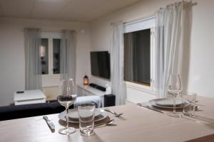 mesa con 2 copas de vino y sala de estar. en Charming house near the city, en Rovaniemi