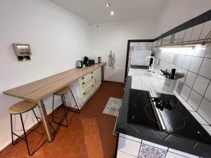 a kitchen with a table and a counter in it at Spacieuse Maison de Village - Baby-foot & Fléchettes in Saint-Brisson-sur-Loire