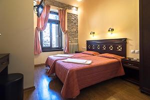 a bedroom with two beds and a window at Guesthouse Aktaion in Afissos