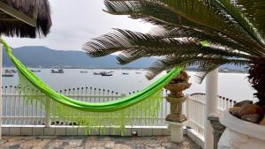 a hammock on a balcony with a view of the water at Apartamento no Costão do Pântano do Sul in Florianópolis +4 photos