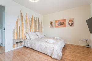 JoeufにあるChambre Jessy 20m - 2 SDB - Balcon - WIFI - Parkの木製のヘッドボードが付いたベッドのある寝室