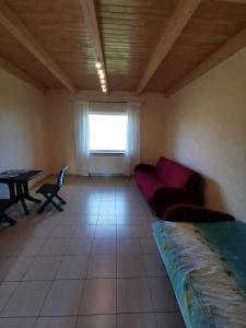a living room with a red couch and a table at Poilsio namai Aerodromas in Bajorai