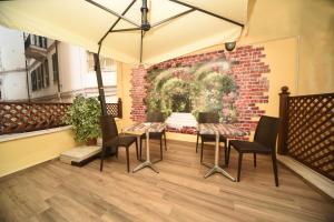 un patio con tavolo, sedie e muro di mattoni di Gioberti House a Sanremo