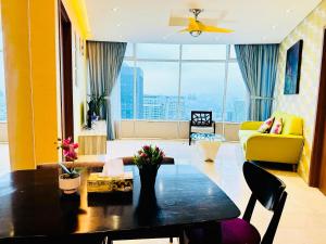 a living room with a table and a yellow couch at APARTMENT VorteX KLCC in Kuala Lumpur