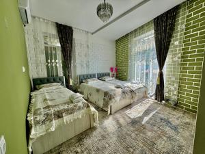 a bedroom with two beds and a brick wall at Samdarvoza in Tashkent