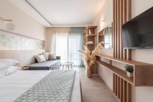 a hotel room with a bed and a tv at Sensi resort Nikiti in Nikiti