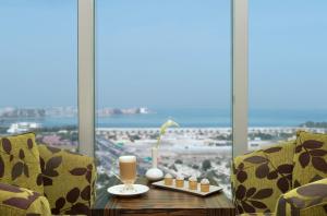 a table in front of a window with a view of the ocean at Atana Hotel in Dubai