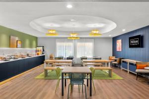 a cafeteria with tables and chairs and a counter at Spark By Hilton Missouri City in Missouri City