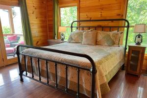 a bedroom with a bed in a log cabin at Smoky Mountain High in Bryson City