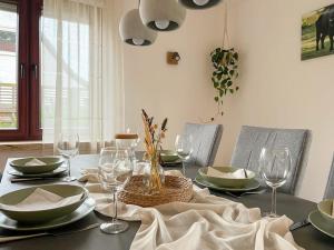 a dining room table with plates and wine glasses at Haus Eichenblick Espelkamp in Espelkamp-Mittwald