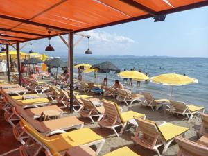 a bunch of chairs and umbrellas on a beach at Paradise Hotel Akcay in Edremit