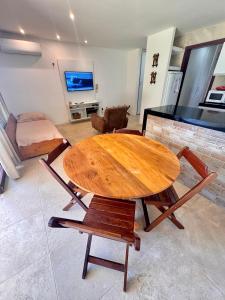 einen Holztisch und Stühle im Wohnzimmer in der Unterkunft Taiba Beach Resort - Ap 106 BL A - IMOB TEMPORADA in Taíba + 37 Fotos