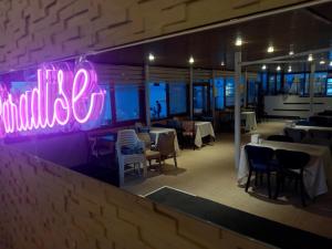 a neon sign on the wall of a restaurant at Paradise Hotel Akcay in Edremit +87 photos