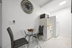 a dining room with a glass table and a refrigerator at Nice,Stylish King Bed Studio in Miami Gardens