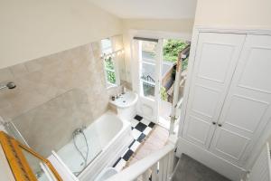 a bathroom with a white tub and a sink at High-ceiling Gorgerous Victorian flat with private garden - 3 mins to Hyde Park, Kensington Palace, 8 mins NottingHill, High Street Kensington station in London