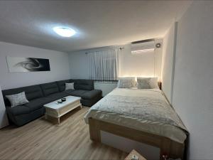 a small bedroom with a bed and a couch at Studio Apartman Karlo in Zaprešić