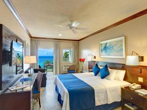 a hotel room with a bed and a living room at Coconut Court Beach Hotel in Bridgetown