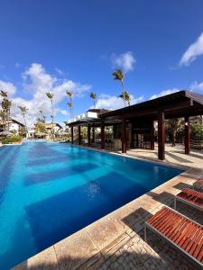 ein großer blauer Swimmingpool mit einem Pavillon in der Unterkunft Taiba Beach Resort - Ap 106 BL A - IMOB TEMPORADA in Taíba