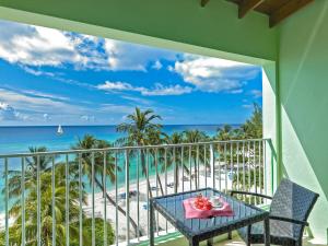 a balcony with a table and a view of the beach at Coconut Court Beach Hotel in Bridgetown