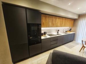 a kitchen with a black refrigerator and a sink at Country View Retreat in Żabbar