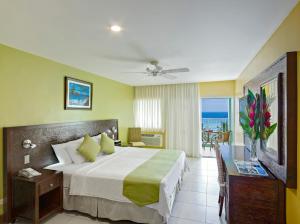 a bedroom with a bed and a view of the ocean at Coconut Court Beach Hotel in Bridgetown