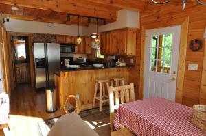 a kitchen with a refrigerator and a table in a cabin at Cherokee Ridge Retreat in Whittier