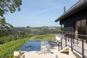a person in a swimming pool next to a house at Vila Slatina Weinderer in Svečina