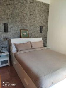 1 cama en un dormitorio con pared de ladrillo en Bungalow Sonemar - Summer Mary GC, en Sonnenland