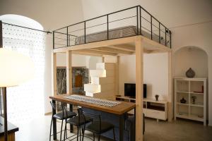 a loft bed in a room with a table and chairs at Fox House in Santeramo in Colle