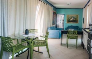 a kitchen and living room with a table and chairs at Apartamentos Primavera Guarujá in Guarujá