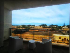 a room with a large window with chairs and a view at Country View Retreat in Żabbar
