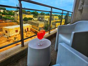 a wine glass sitting on a table in front of a window at Country View Retreat in Żabbar