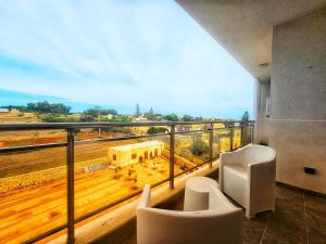 a balcony with chairs and a view of a building at Country View Retreat in Żabbar