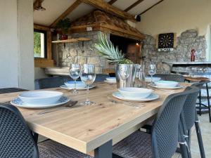 a wooden table with plates and wine glasses on it at Villa Jelly in Šmrika