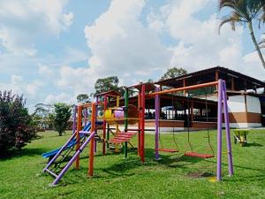 a playground with colorful equipment in a park at FINCA HOTEL LAS CABAÑAS DEL Parque in Pueblo Tapao