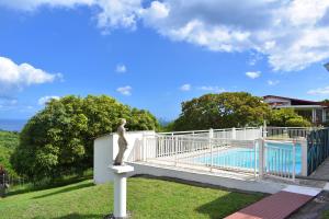 a statue of a woman standing on a pole next to a pool at Lauramar Avocado - Vue Mer et Montagne in Le Morne aux Bœufs