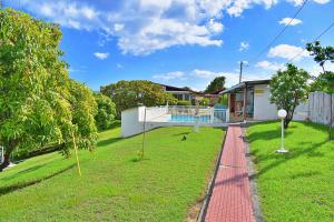 a house with a red brick walkway in front of a yard at Lauramar Avocado - Vue Mer et Montagne in Le Morne aux Bœufs