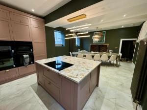 a kitchen and dining room with a table in the background at Secret Garden House - 7 bed Manor House with Hot Tub and Magical walled Gardens in Leyburn