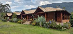 a wooden house with some plants in front of it at Refúgio Mantiqueira - Parte Alta Parque Nacional Itatiaia in Itamonte